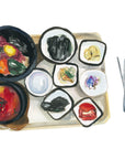 Korean lunch print of painting by Medjool Studio. Watercolour painting featuring a traditional Korean meal from Seoul including traditional soup, rice, bipimpap, kimchi, and other sides.