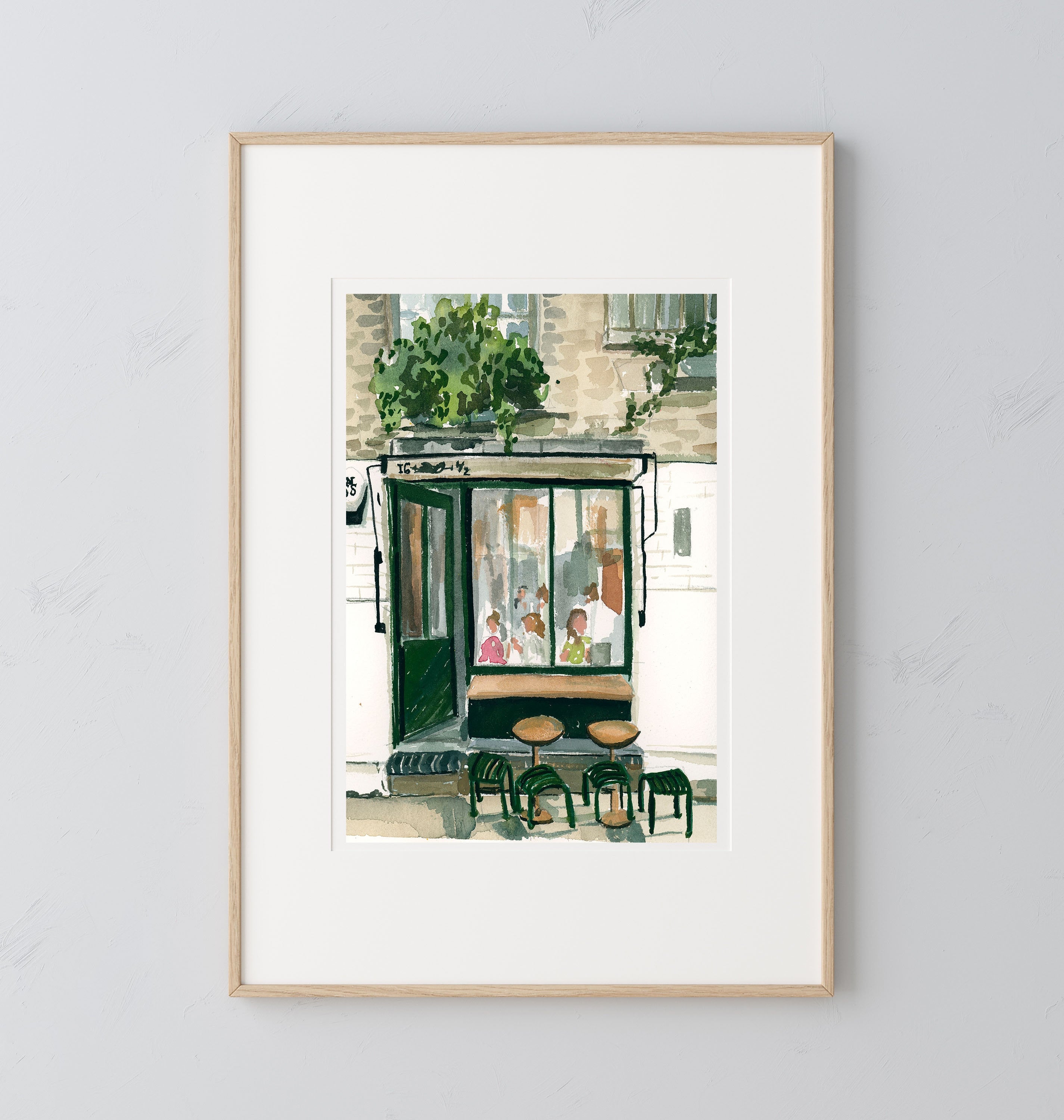 London cafe print of painting by Medjool Studio. Print of original gouache painting of a coffee shop in London, England full of customers and two small tables with stools out front.