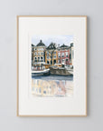 Amsterdam canal print of painting by Medjool Studio. Print of original gouache painting with brown, yellow and red building features behind small boats in the water from the Amsterdam canal.