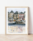 Amsterdam canal print of painting by Medjool Studio. Print of original gouache painting with brown, yellow and red building features behind small boats in the water from the Amsterdam canal.